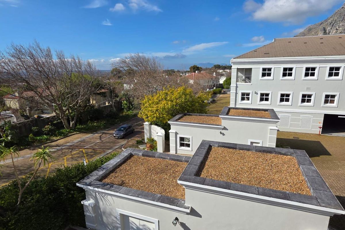 Aerial view of the office property complex, showcasing the building architecture, paved driveway, and surrounding landscaped grounds.