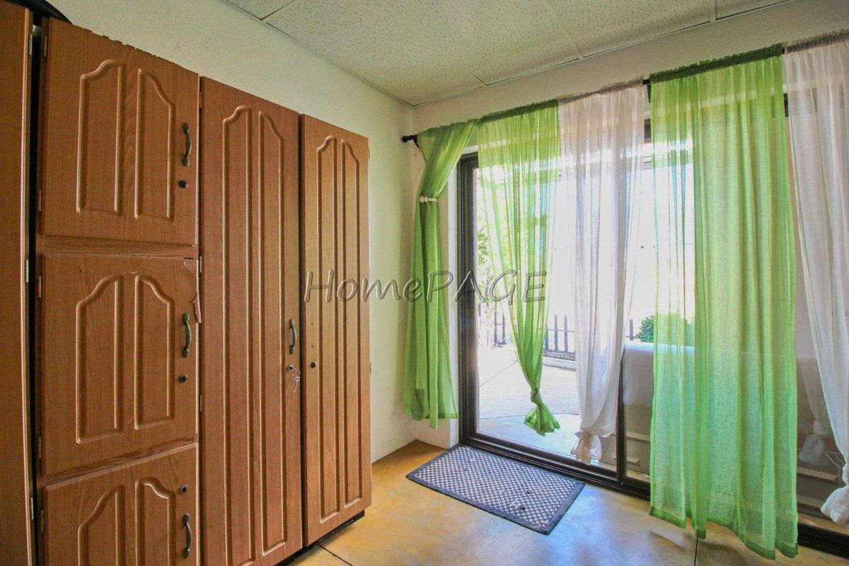 A bedroom featuring built-in wooden wardrobes and a sliding glass door providing access to an outdoor area.