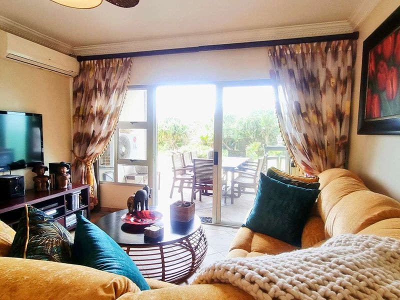 A comfortable living room featuring tiled flooring, cornice detailing, and a split-system air conditioner, with direct access to an outdoor patio area.