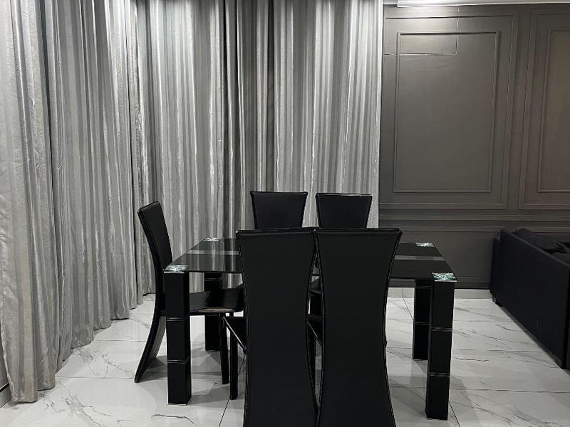Modern dining area featuring polished marble-look floor tiles, elegant wainscoting wall detailing, and recessed ceiling lighting.