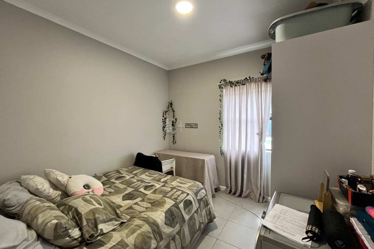 A standard bedroom featuring neutral wall paint, tiled flooring, and decorative cove cornicing, providing a functional and well-lit living space.