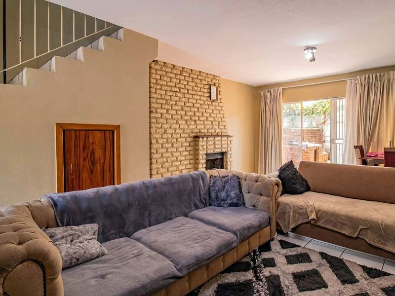 Living room featuring a brick fireplace, under-stair storage, and sliding glass doors leading to an outdoor area.
