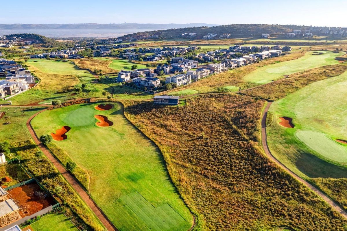 An aerial view of a residential estate integrated with a golf course, showcasing the surrounding landscape and neighborhood layout.