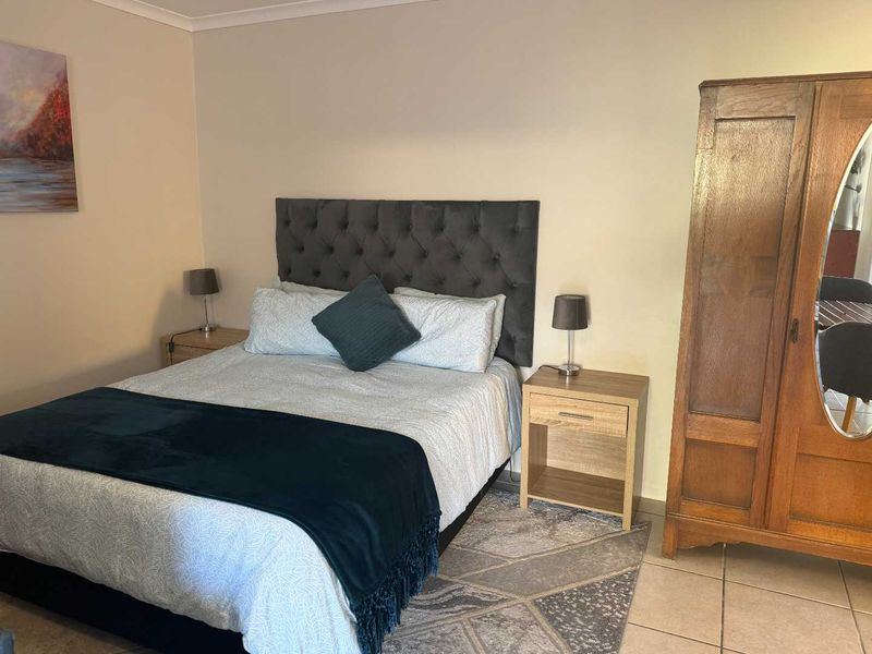 A functional bedroom featuring tiled flooring and neutral wall finishes, providing a comfortable and practical living space.