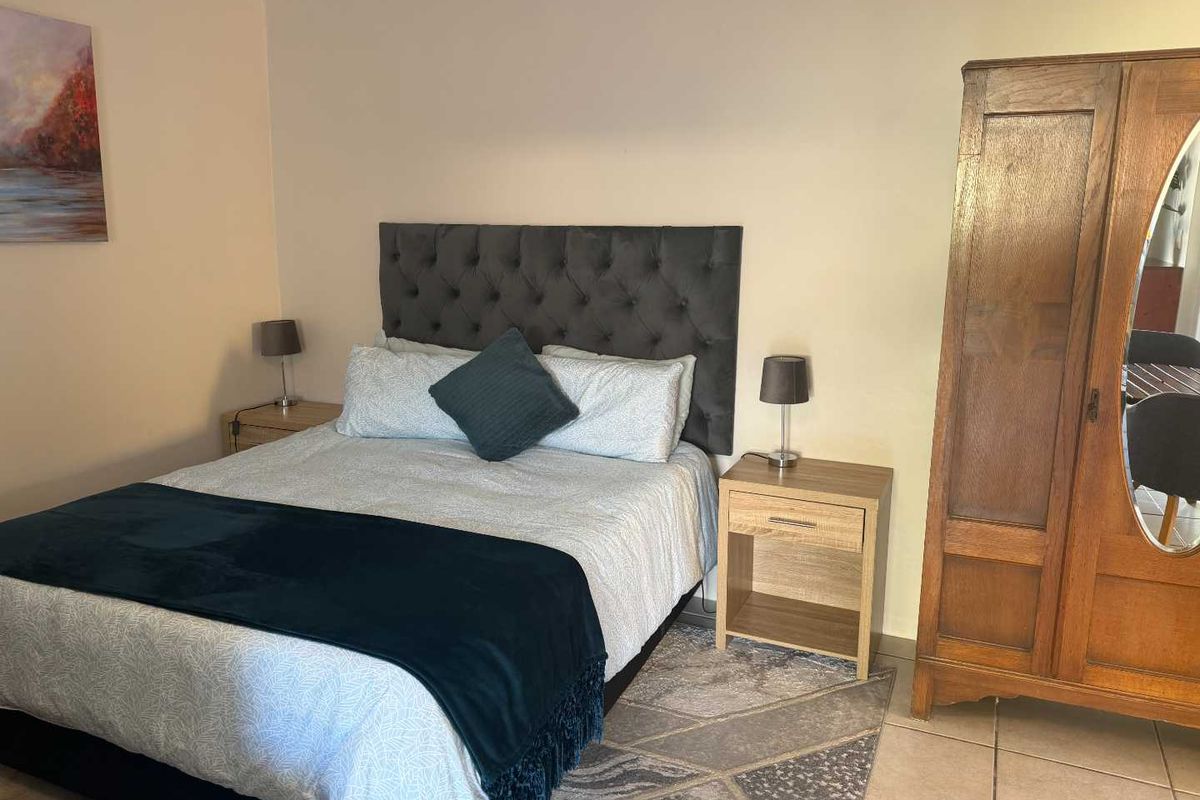 A functional bedroom featuring tiled flooring and neutral wall finishes, providing a comfortable and practical living space.