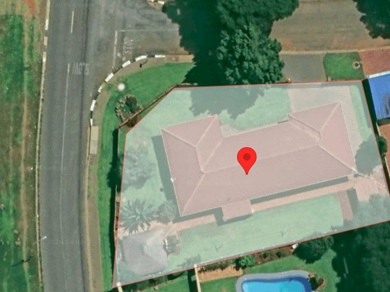 Aerial view of the property showing the roof structure, surrounding garden area, and swimming pool.