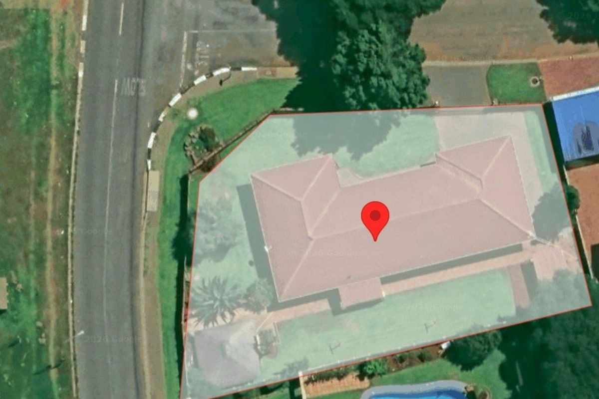 Aerial view of the property showing the roof structure, surrounding garden area, and swimming pool.