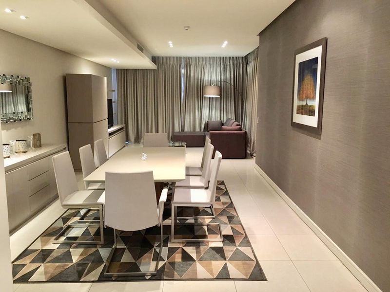 A well-maintained dining area featuring modern tiled flooring, recessed ceiling lighting, and sleek built-in cabinetry, creating a sophisticated and functional space.