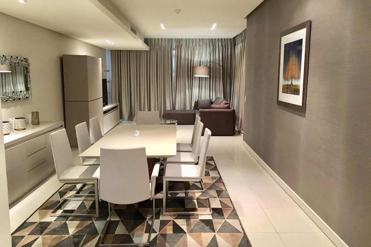 A well-maintained dining area featuring modern tiled flooring, recessed ceiling lighting, and sleek built-in cabinetry, creating a sophisticated and functional space.