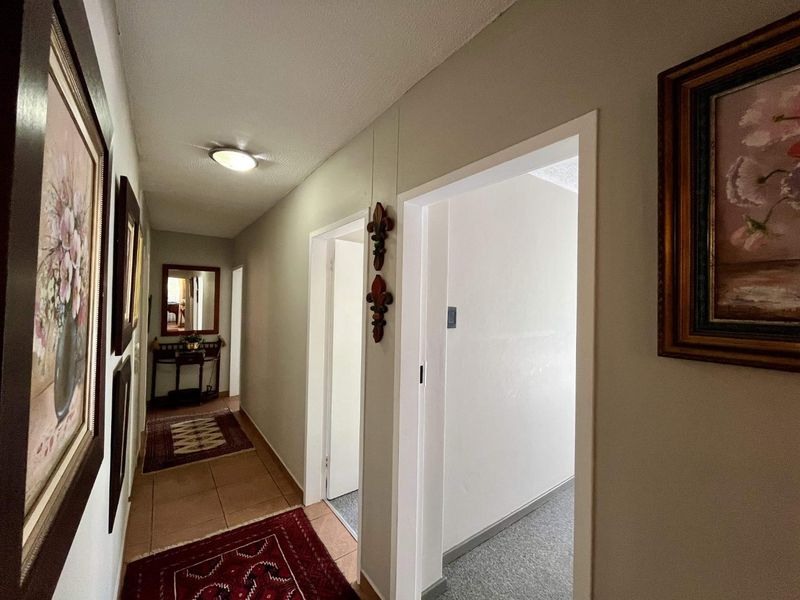 A well-lit interior hallway featuring tiled flooring, providing access to multiple rooms within the townhouse.