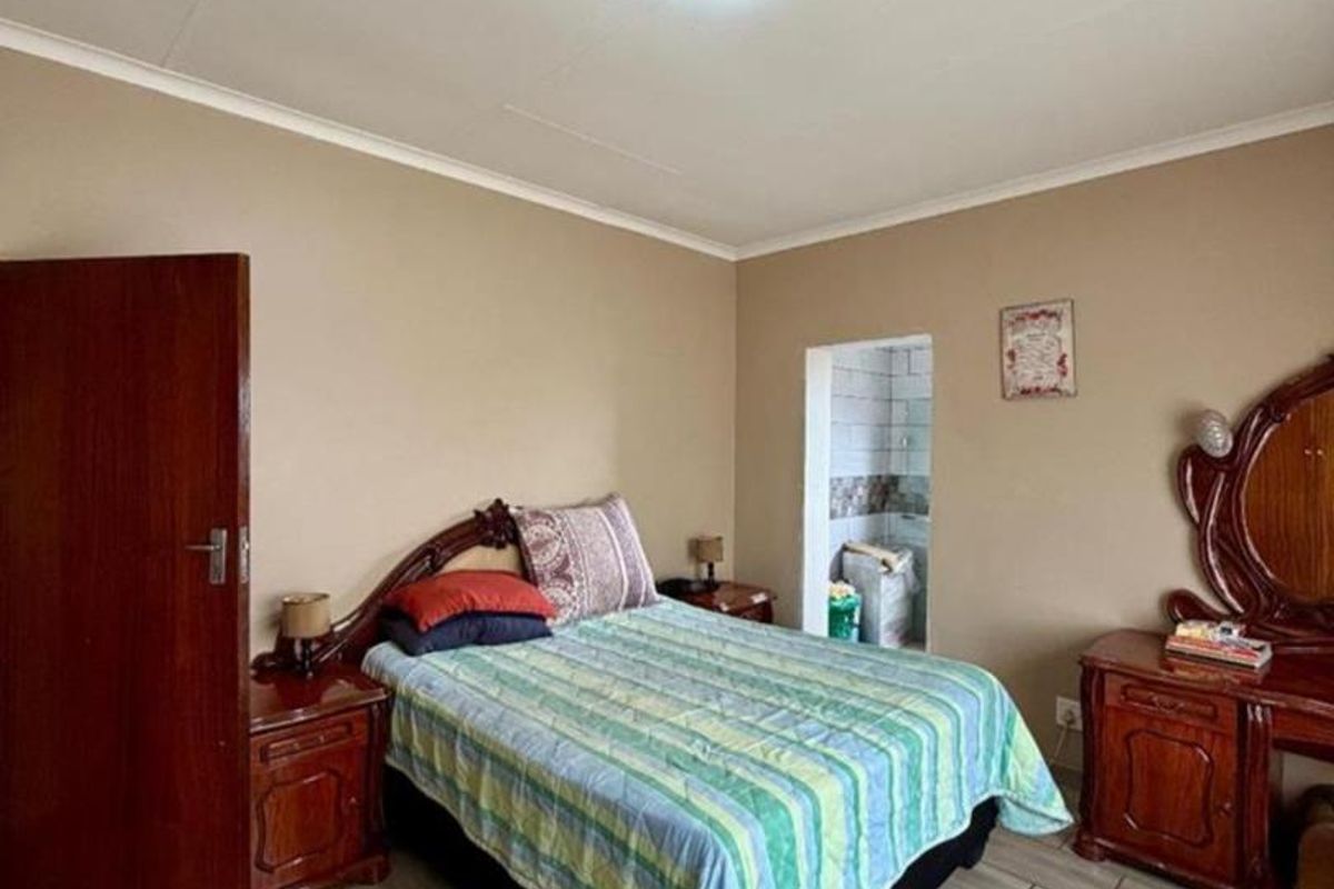 A bedroom featuring tiled flooring and neutral wall finishes, with an adjacent small tiled alcove area.