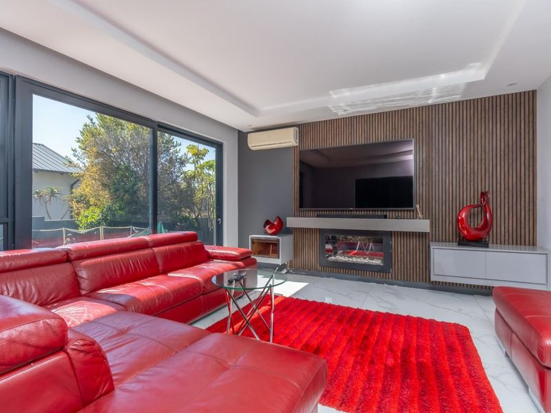 Modern living room featuring a timber slat feature wall, built-in fireplace, split-system air conditioning, and large sliding glass doors leading to the exterior.