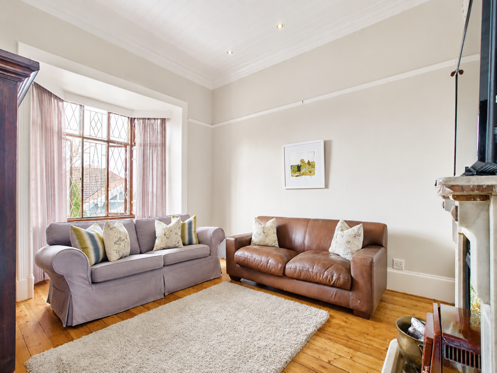 Lounge with high ceilings and natural lighting and a vintage fireplace