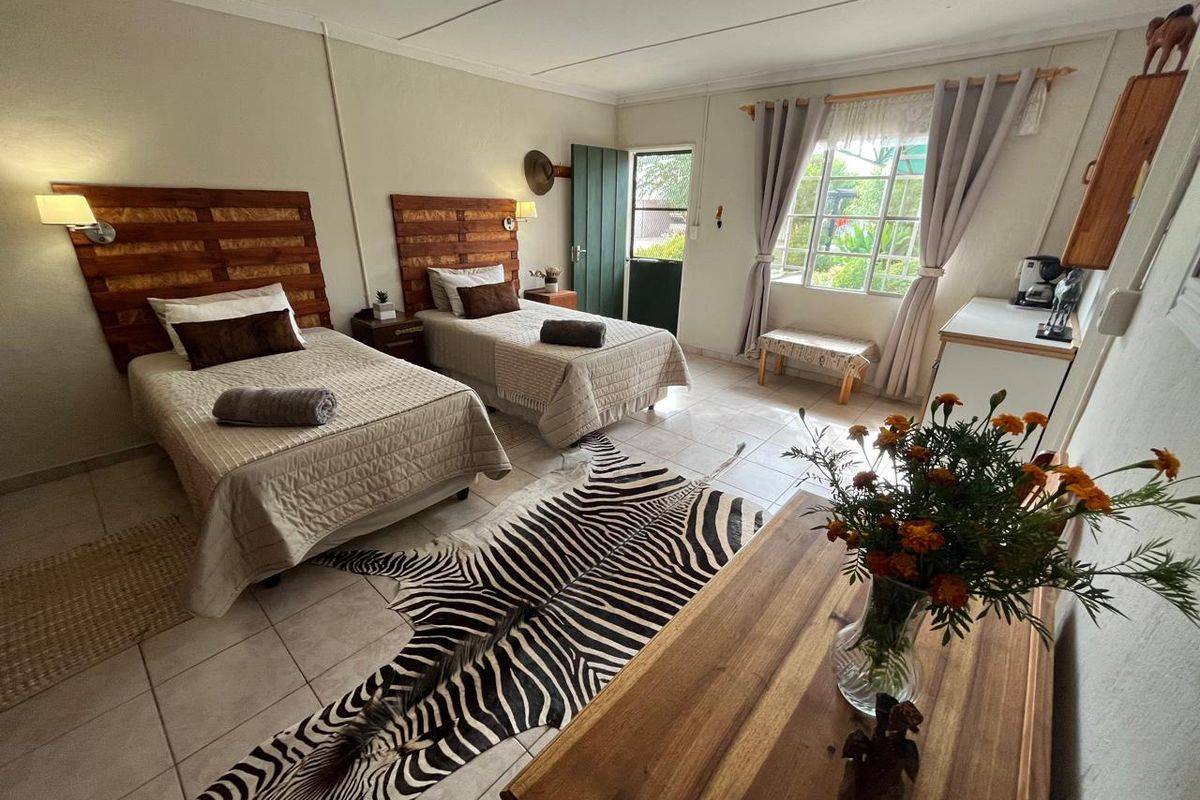 A well-maintained bedroom featuring tiled flooring, a private exterior door, and large windows allowing for natural light.