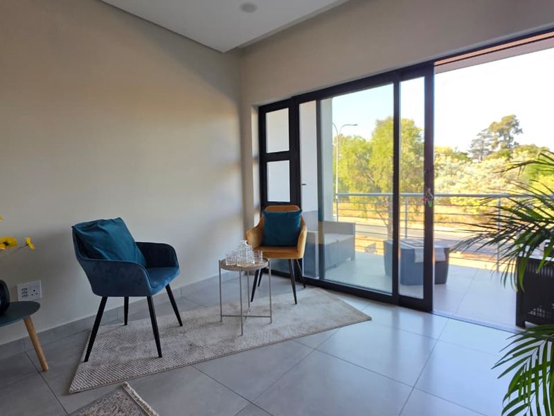 Bright living area featuring large sliding glass doors that provide seamless access to an outdoor balcony and ample natural light.