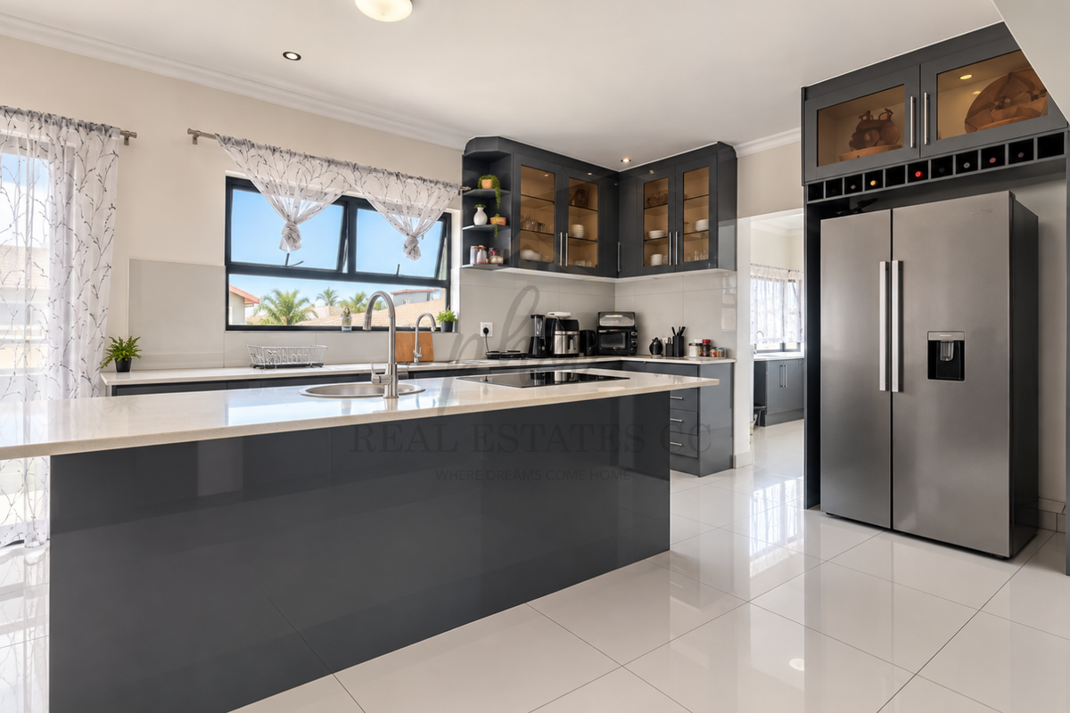 Modern kitchen featuring a large island with quartz countertops, sleek dark cabinetry, integrated appliances, and polished porcelain floor tiles.