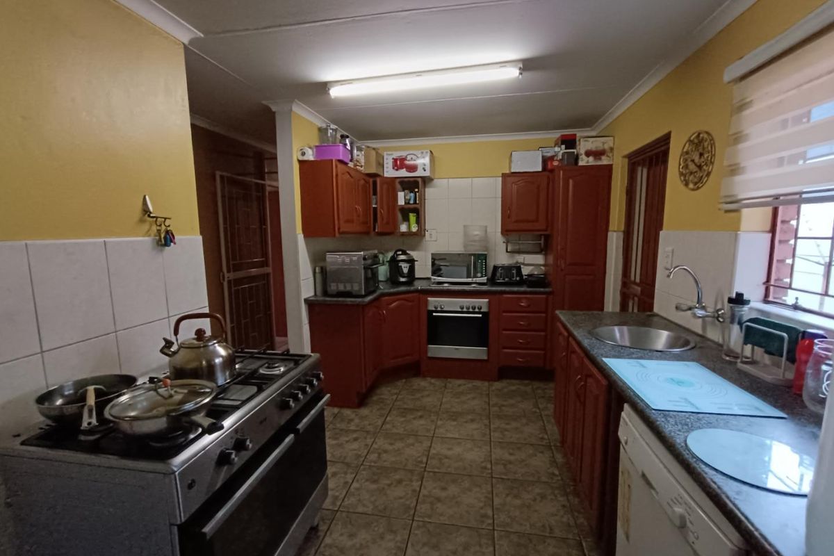 Functional kitchen featuring wooden cabinetry, tiled splashbacks, a built-in oven, and a gas stove, offering a practical layout for daily meal preparation.