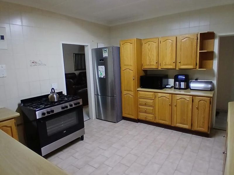 A functional kitchen featuring wooden cabinetry, tiled backsplash, and a gas stove, offering a practical layout with ample storage space.