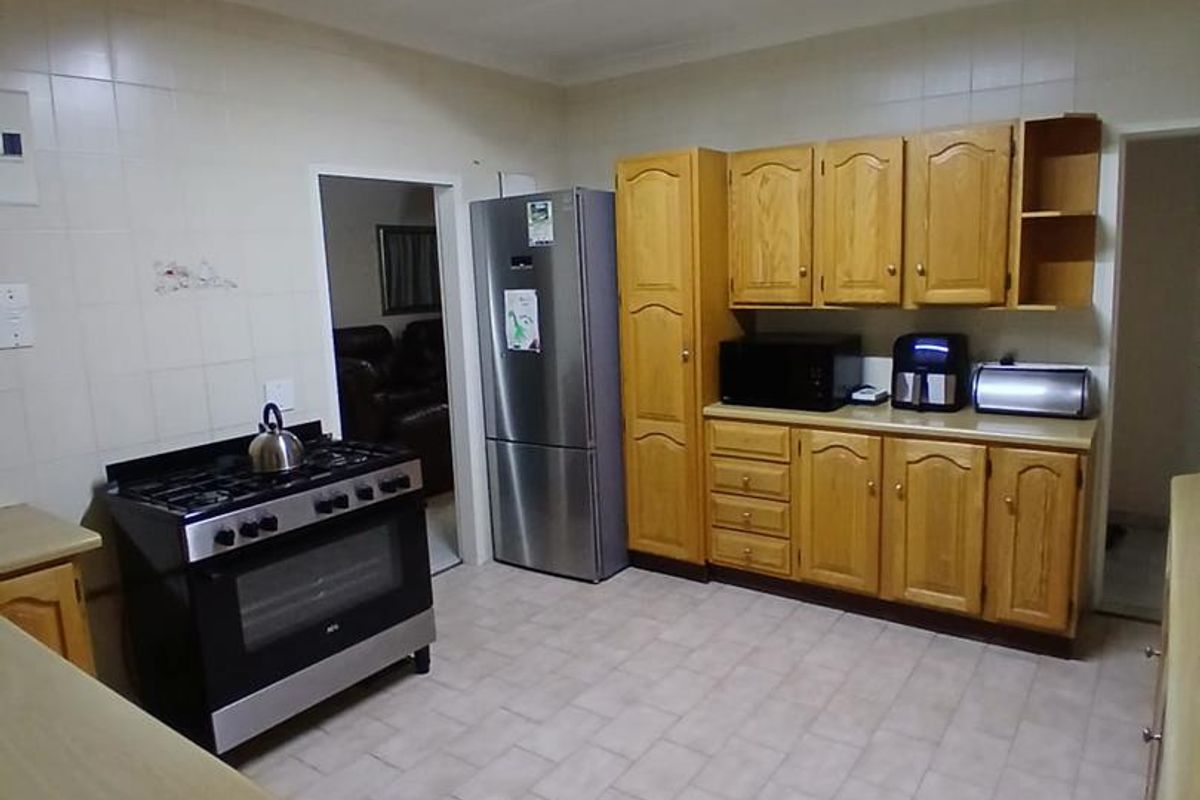 A functional kitchen featuring wooden cabinetry, tiled backsplash, and a gas stove, offering a practical layout with ample storage space.