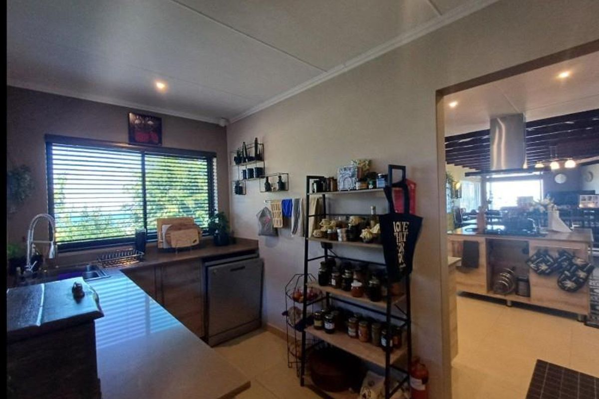 A functional kitchen area featuring stone countertops, integrated cabinetry, and a view into the adjacent living space.