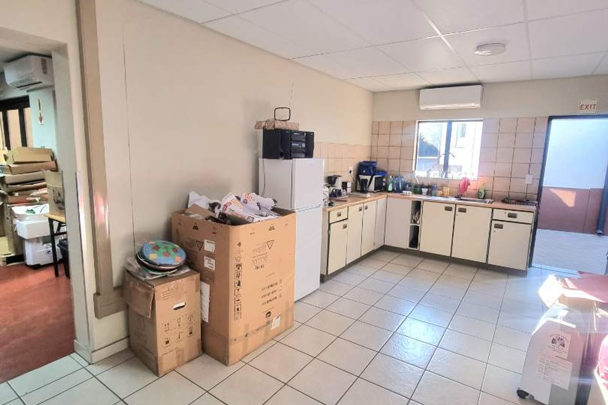 A functional kitchen area featuring tiled flooring, built-in cabinetry with a tiled backsplash, and a split-system air conditioning unit.