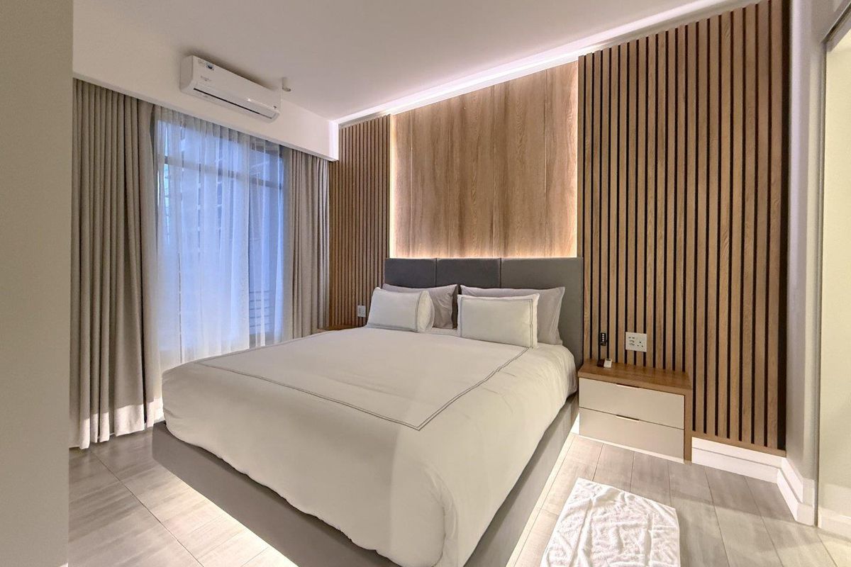Modern bedroom featuring timber slat wall paneling, integrated LED accent lighting, wall-mounted air conditioning unit, and neutral floor tiling.