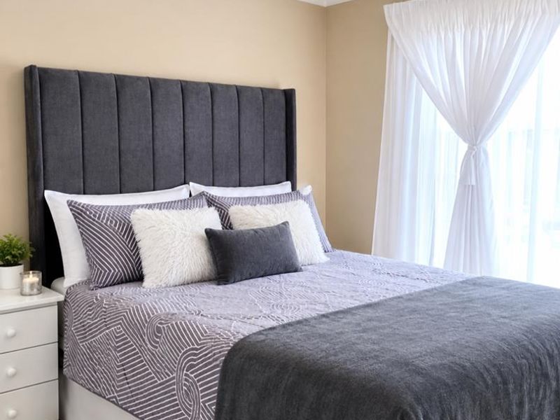 A well-maintained bedroom featuring neutral wall tones, tiled flooring, and modern ceiling spotlighting, creating a clean and comfortable living space.