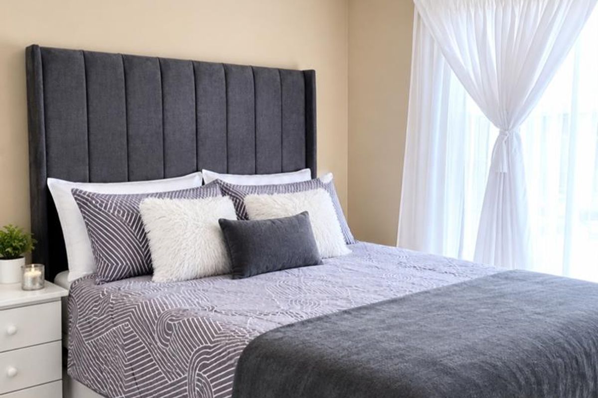 A well-maintained bedroom featuring neutral wall tones, tiled flooring, and modern ceiling spotlighting, creating a clean and comfortable living space.