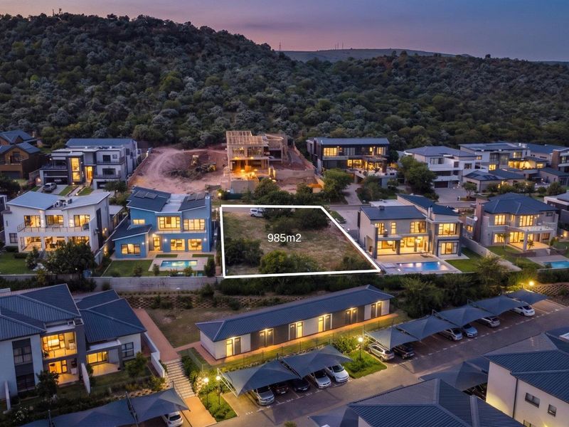 An aerial view of a 985m2 vacant residential plot situated within a developed estate, ready for new construction.