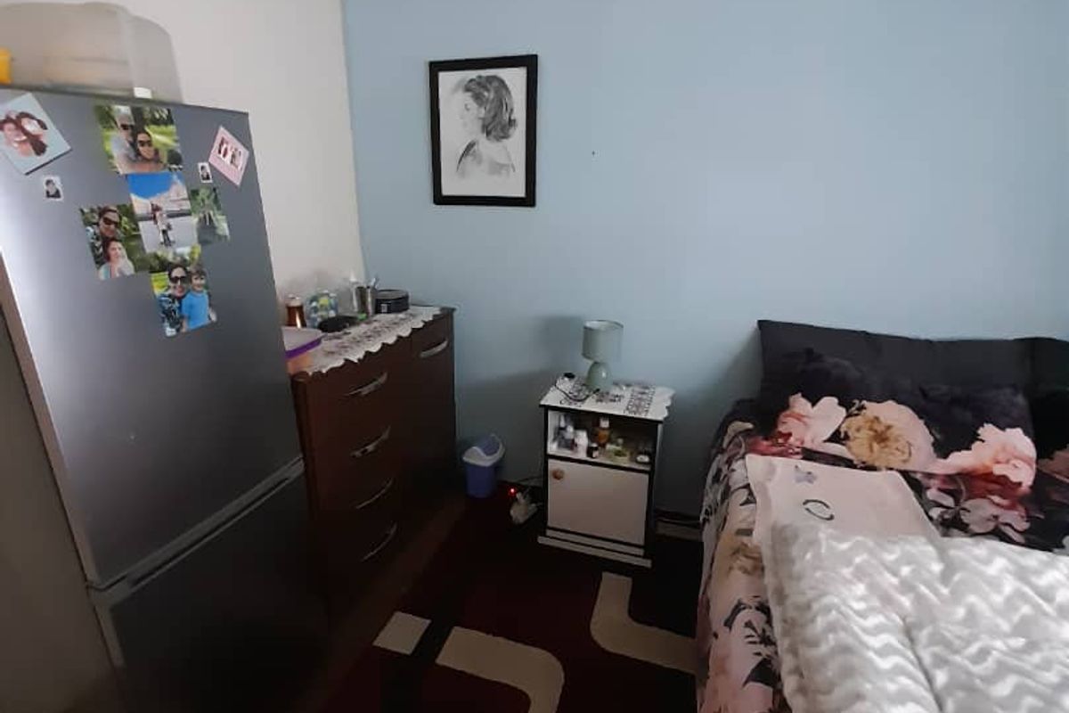 A bedroom featuring a light blue accent wall, neutral flooring, and standard ceiling finishes.