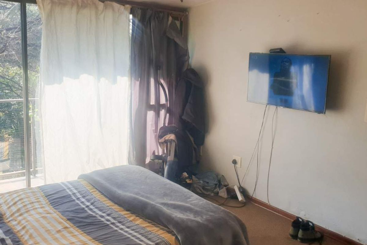 A bedroom featuring a ceiling fan, carpeted flooring, and a sliding glass door providing access to an outdoor area.
