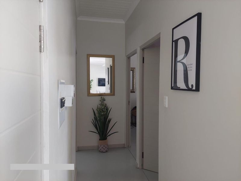 A clean and well-maintained hallway featuring neutral walls, internal doors, and a tongue and groove ceiling.