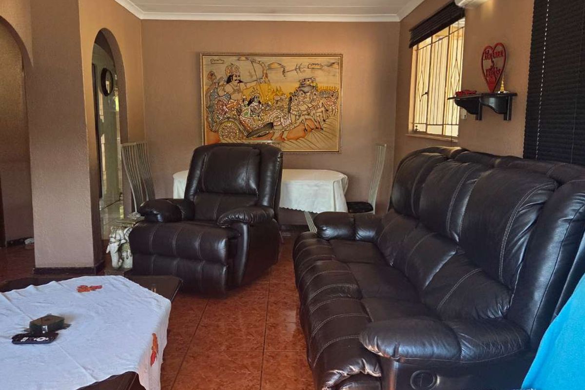 A living room featuring tiled flooring, an archway entrance, and a wall-mounted air conditioning unit.