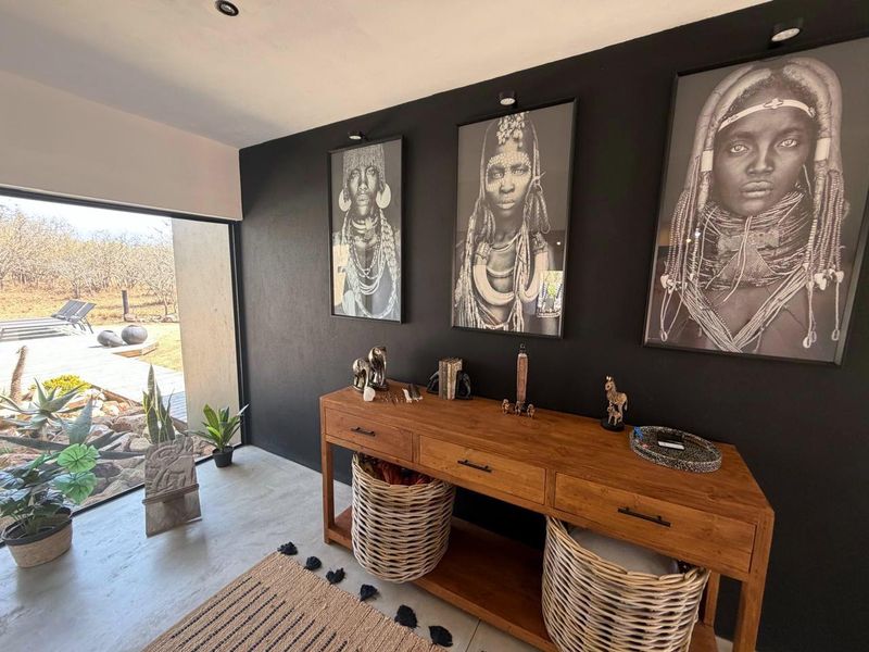 A modern living space featuring polished concrete floors, recessed lighting, and a large sliding glass door providing seamless access to the outdoor area.