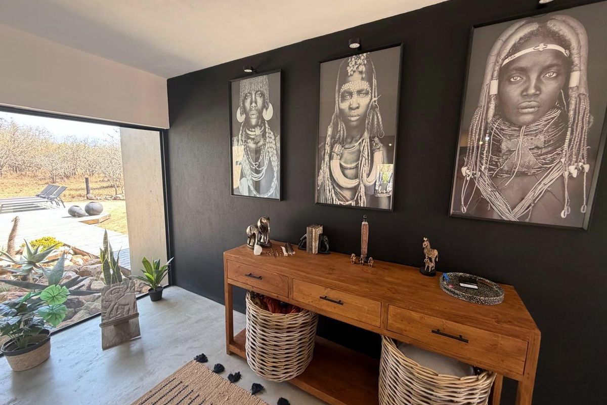 A modern living space featuring polished concrete floors, recessed lighting, and a large sliding glass door providing seamless access to the outdoor area.