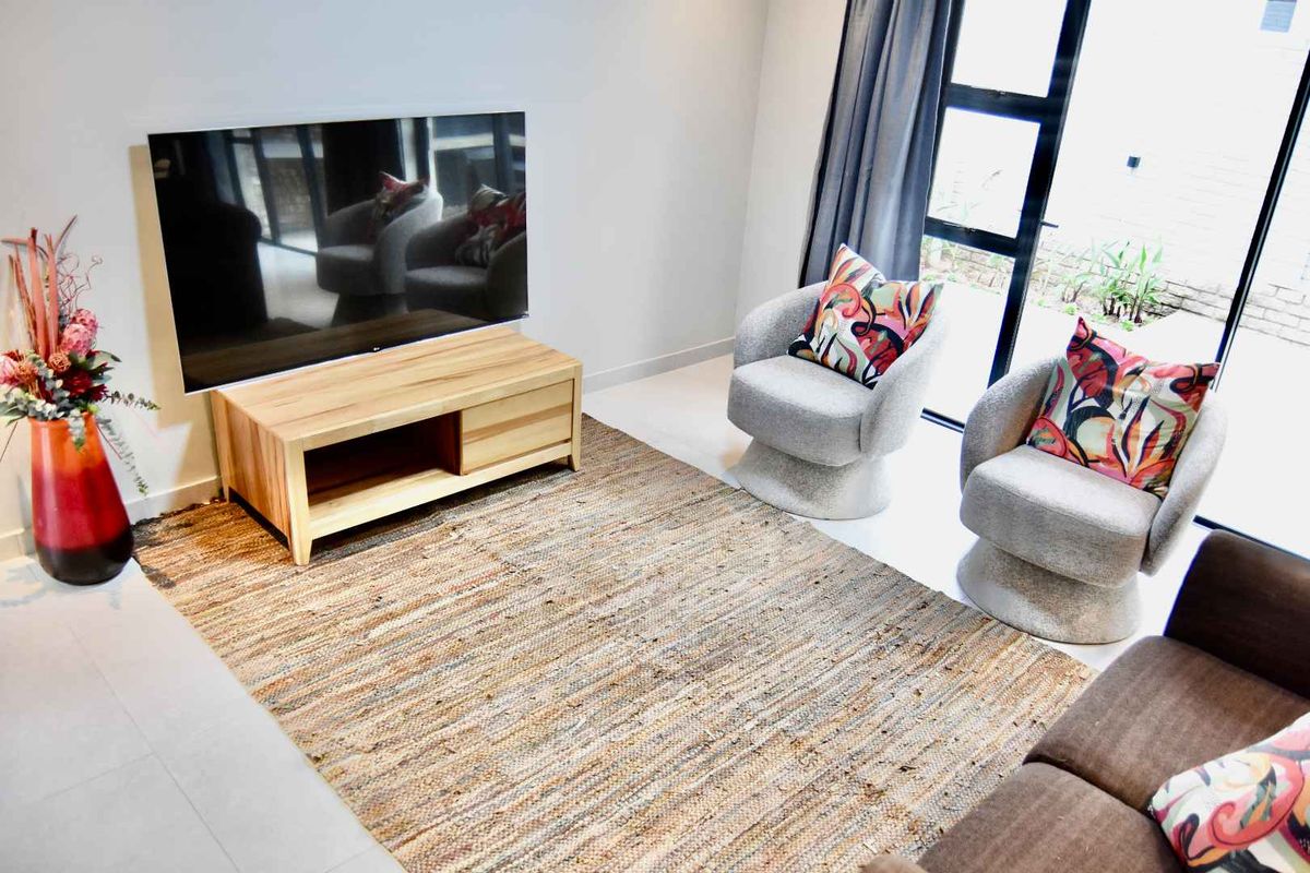 A bright living room featuring large glass sliding doors that provide natural light and direct access to the outdoor area.