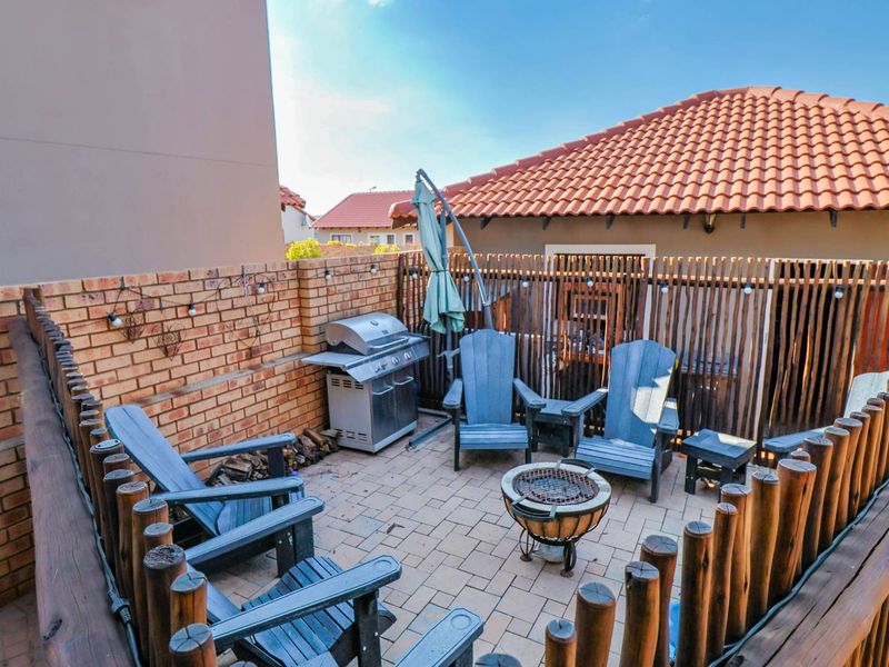 A private outdoor patio area featuring paved flooring, brick boundary walls, and timber fencing, providing a cozy space for outdoor relaxation and entertainment.