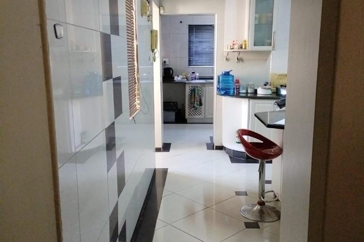 A functional kitchen area featuring tiled flooring, built-in cabinetry, and a breakfast bar, providing a practical layout for daily meal preparation.