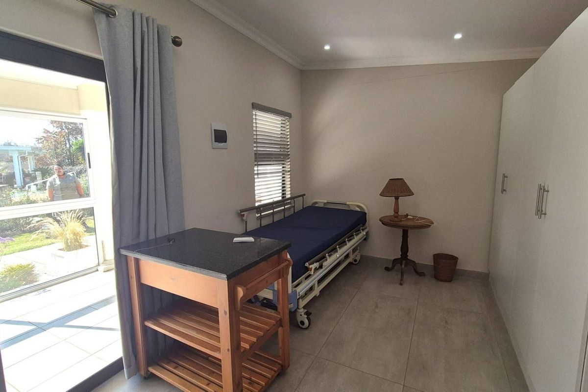 A bedroom featuring tiled flooring, built-in cupboards, recessed ceiling lighting, and a sliding door providing direct access to an outdoor patio area.