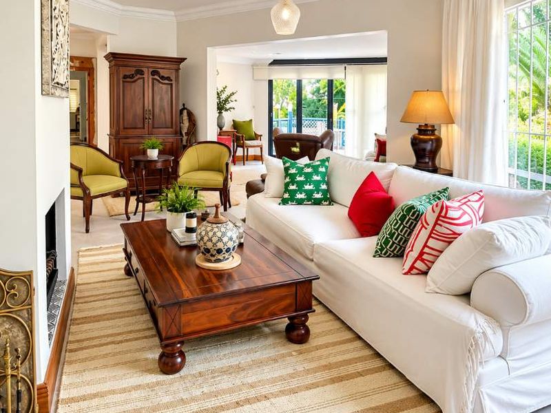 A bright and inviting living room featuring tiled flooring, crown molding, and a fireplace, with large windows providing natural light and garden views.