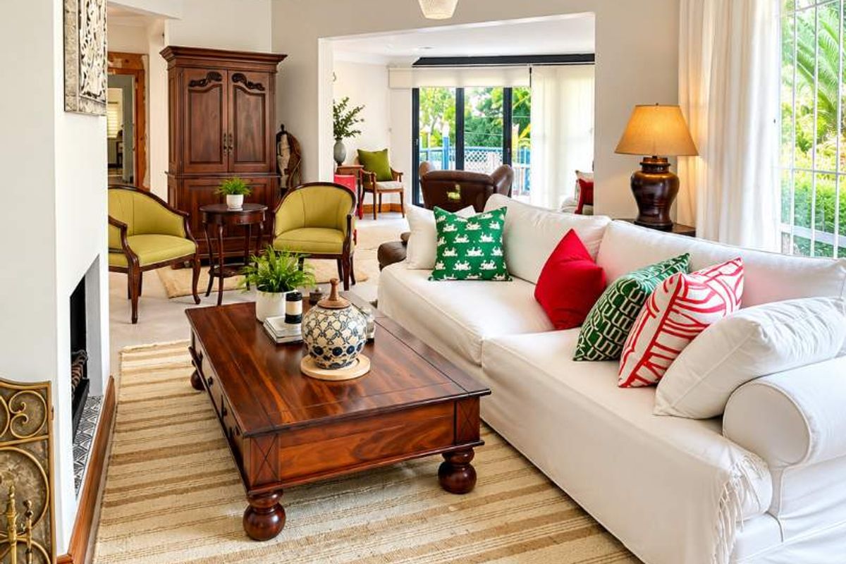 A bright and inviting living room featuring tiled flooring, crown molding, and a fireplace, with large windows providing natural light and garden views.