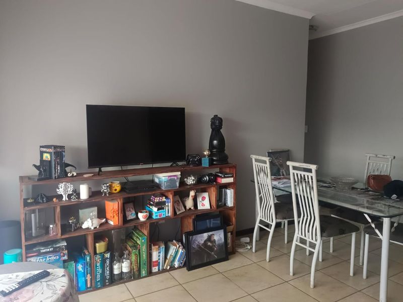 Open plan living and dining area featuring neutral wall tones and tiled flooring throughout.