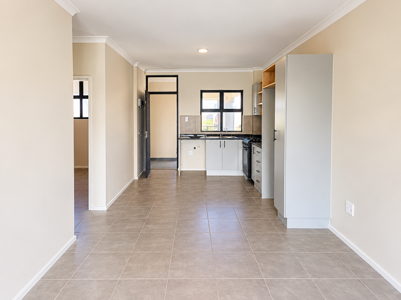 A clean, modern kitchen featuring tiled flooring, built-in cabinetry, and integrated oven, offering a functional and well-maintained space.