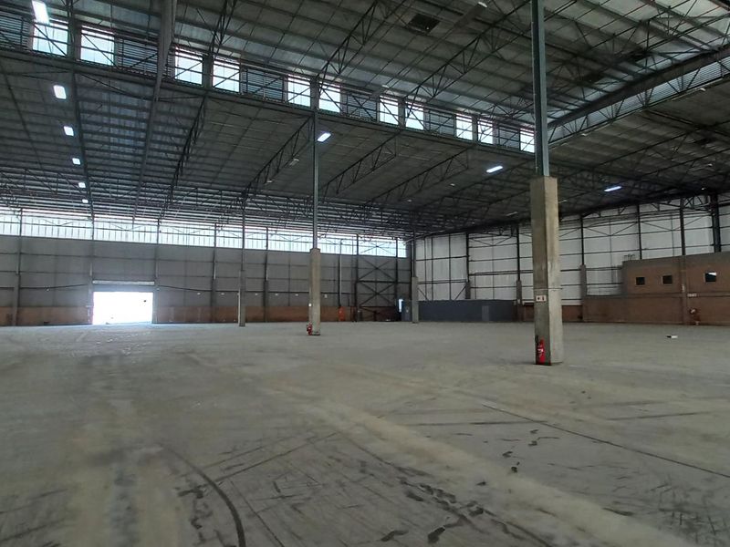 Expansive industrial warehouse space featuring high ceilings, steel portal frame construction, durable concrete flooring, and ample natural light through clerestory windows.
