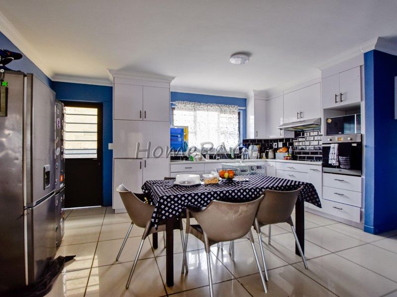 A functional kitchen featuring white cabinetry, tiled backsplash, built-in oven, and tiled flooring, providing a practical space for cooking and dining.