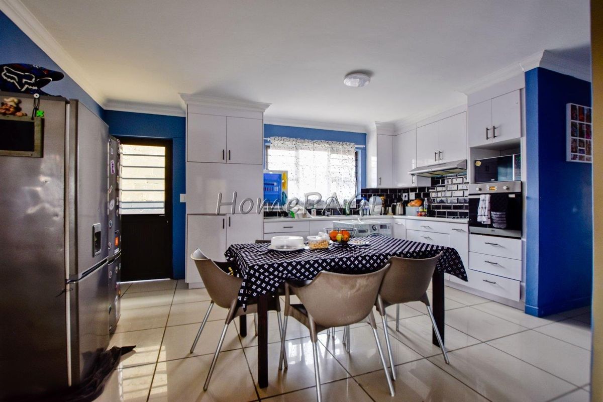 A functional kitchen featuring white cabinetry, tiled backsplash, built-in oven, and tiled flooring, providing a practical space for cooking and dining.