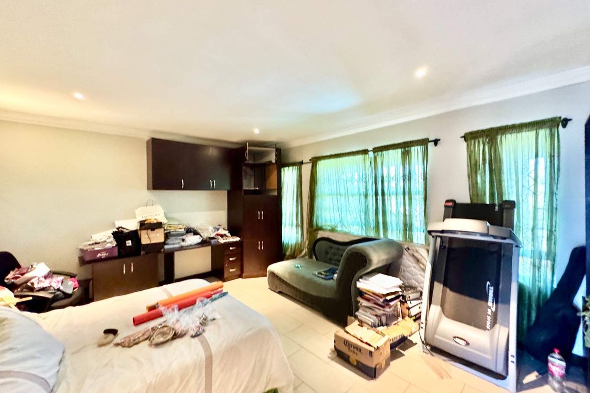 A bedroom featuring built-in cabinetry, tiled flooring, and recessed ceiling lighting, offering a functional space with potential for personalization.