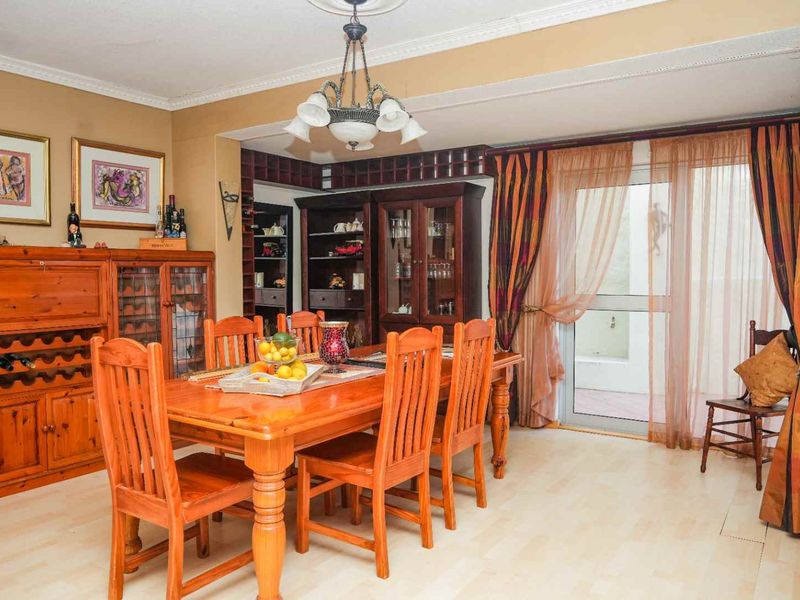 Dining room featuring built-in wine storage and display cabinetry, with direct access to the outdoor area through a glass sliding door.