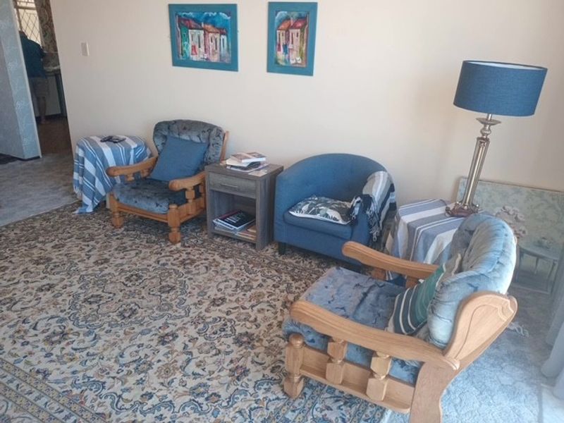 A living room area featuring carpeted flooring and neutral wall finishes.