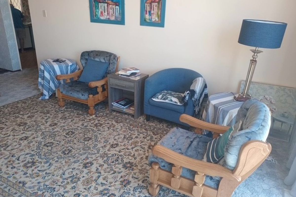 A living room area featuring carpeted flooring and neutral wall finishes.
